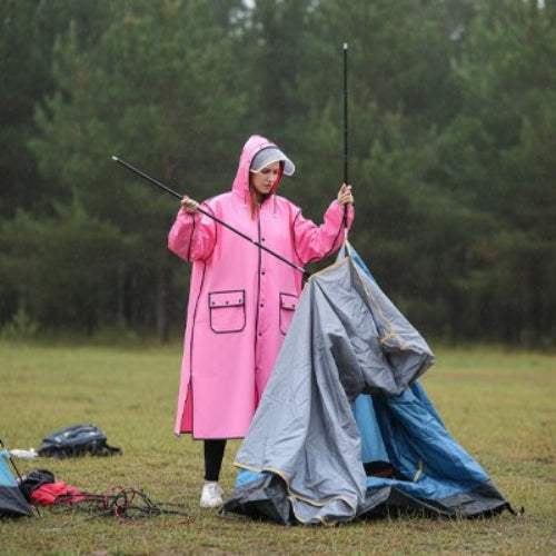 femme avec Poncho pluie rose installant tente