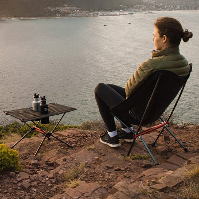 Femme sur Chaise de camping explorant du regard la rivière