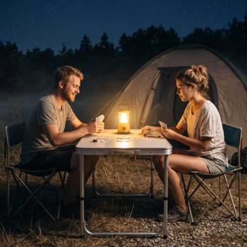 Coupe jouant aux carte sur une table de Camping le soir