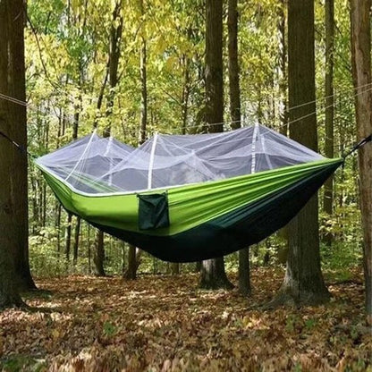 couple dans Hamac moustiquaire vert päle en forêt