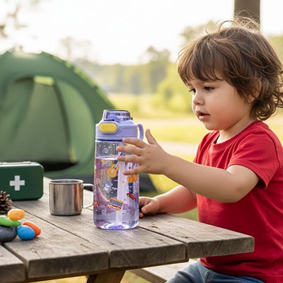 enfant depose gourde enfant sur table de camping