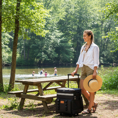 Femme arrive avec Glacière sac isotherme 35L noir à la table de camping