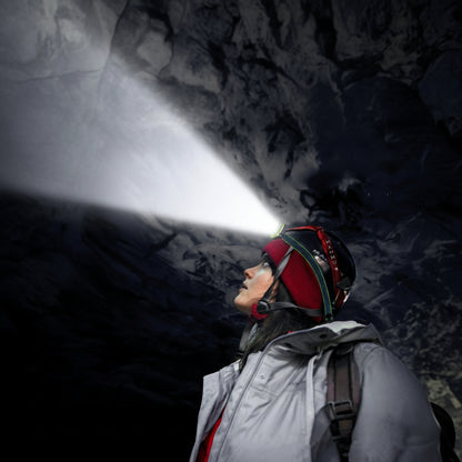 femme avec lampe frontale explorant une grotte