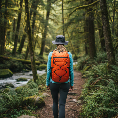 Femme avec sac a dos orange dans sentiers forestier