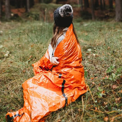 Femme dans Sac de couchage grand froid regardant la forêt