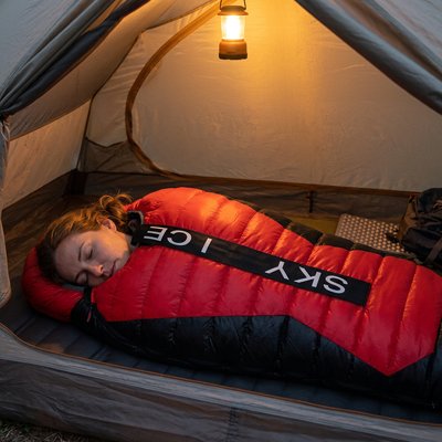 Femme dans Sac de couchage pour grand froid dans sa tente