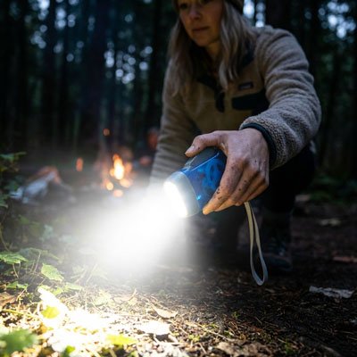 Femme regarde avec Lampe de poche le sol 
