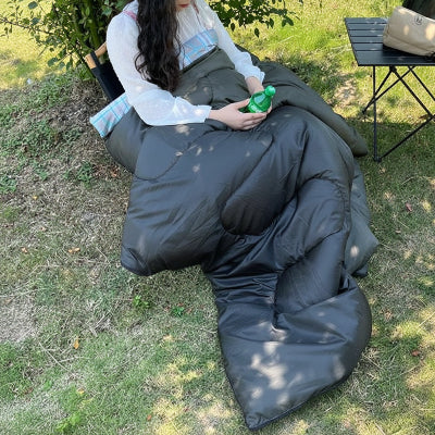Femme se repose sous un arbre dans Sac de couchage grand froid