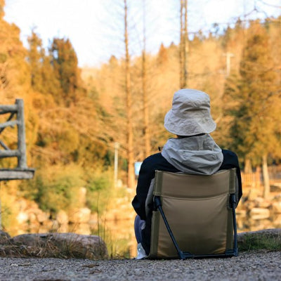 Femme sur Chaise de camping admirant le paysage forestier