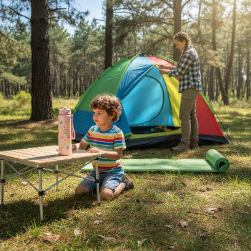 Gourde isotherme rose sur table de camping avec enfant près