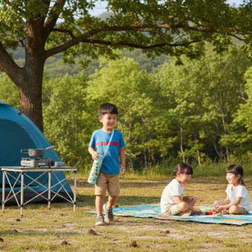 Gourde isotherme vert avec enfant se promenant dans camping