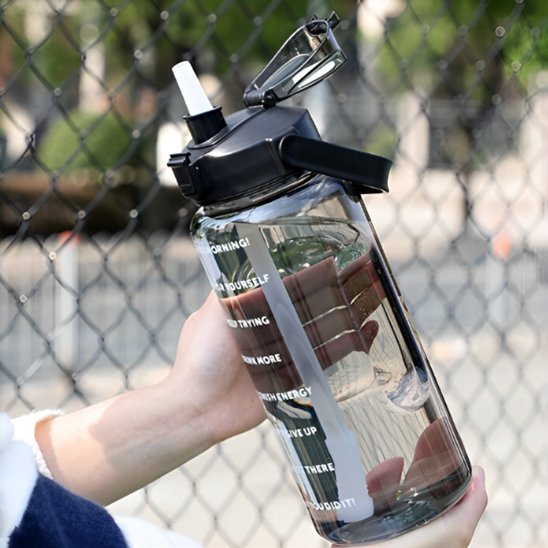 Gourde plastique aquanomad transparente dans une main