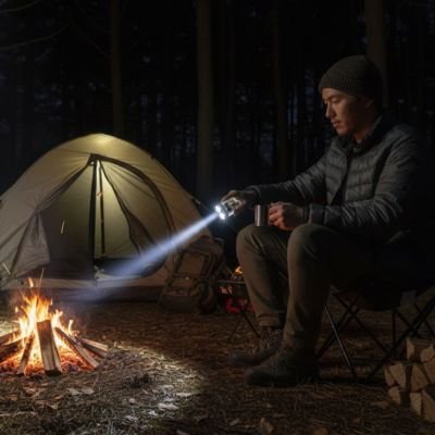 Homme avec Lampe de poche rechargeable près d'un feux 