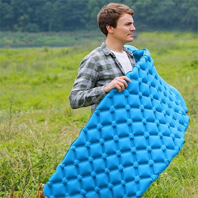 Homme avec Matelas gonflable 1 personne bleu dans ses mains  