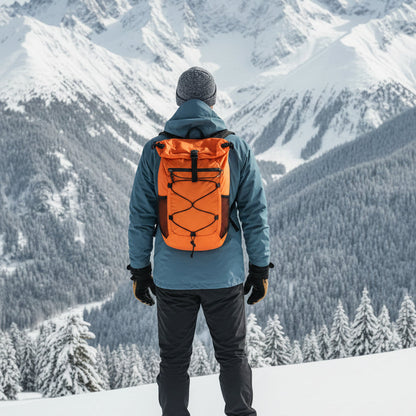 homme avec sac a dos orange avec paysage de montagne enneigé