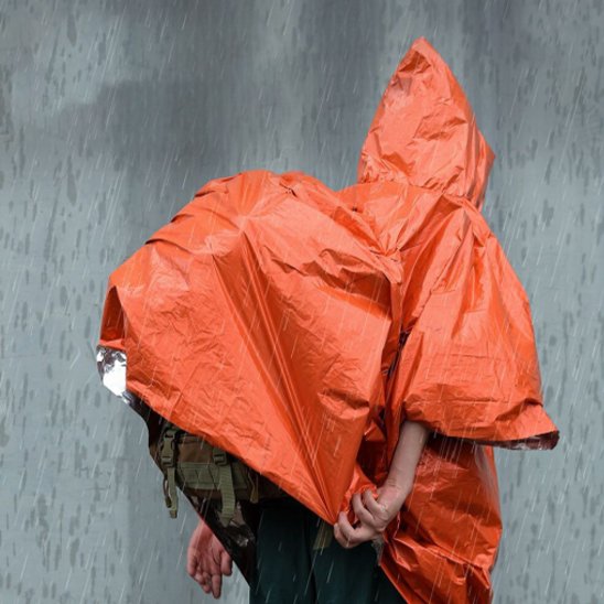 Homme avec sac a dos recouvert par le  Poncho pluie 