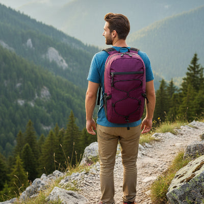 homme dans un sentier montagneux avec sac à dos pourpre