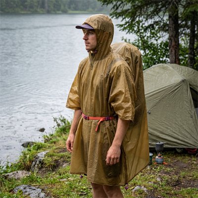 Homme en camping avec Poncho pluie admirant la rivière