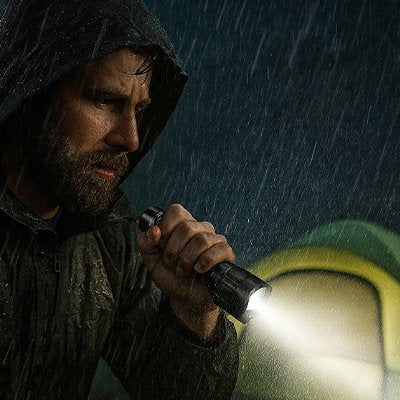 Homme sous la pluie avec Lampe de poche imperméable 