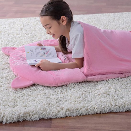 jeune fille fait sa lecture dans Sac de couchage enfant 