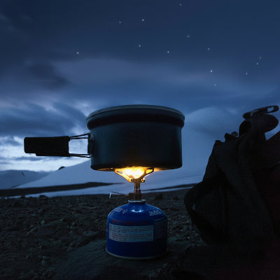Mini réchaud à gaz en action pour faire bouillir l'eau de la casserole 